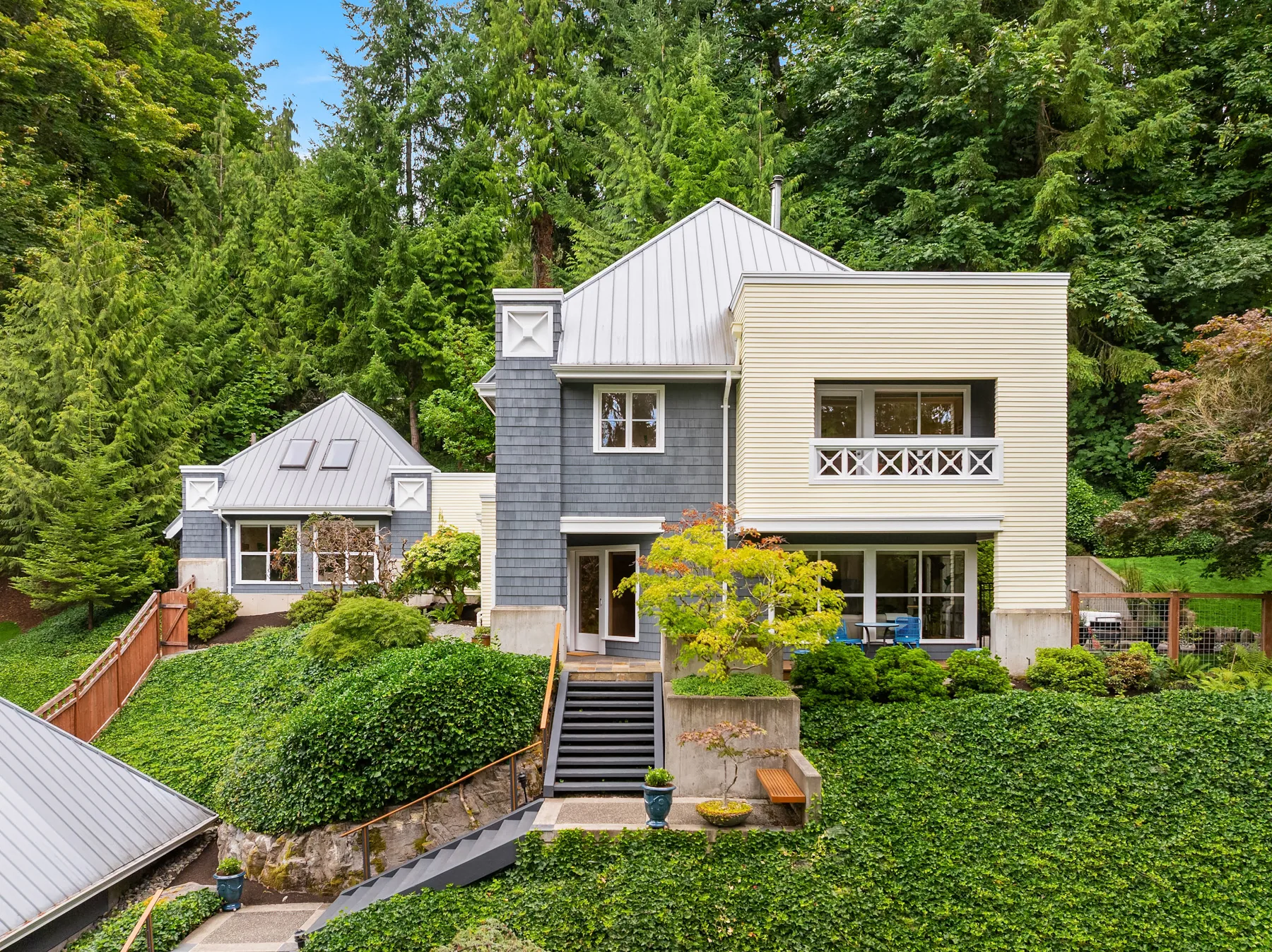Hidden Cove residence exterior, a gabled shingled home set among Pacific Northwest forest